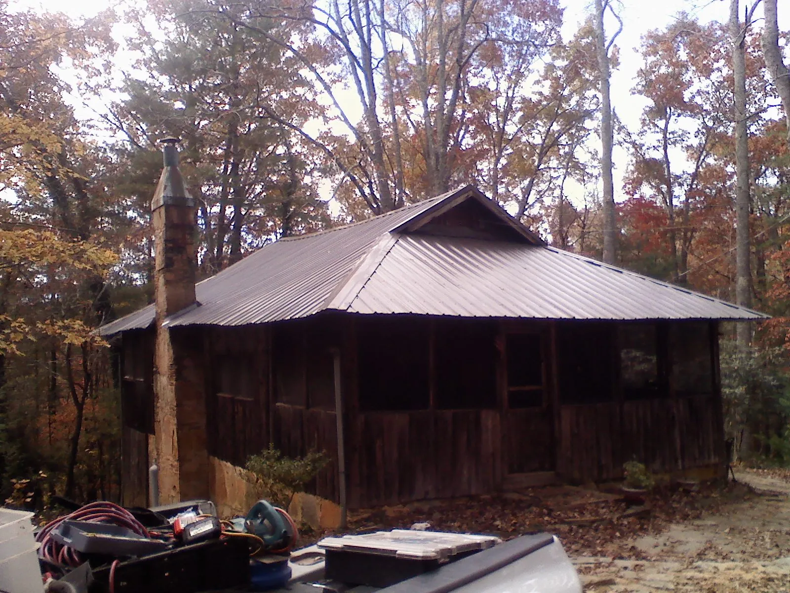Brown metal hip roof on an old cabin with a stone chimney in Fredonia